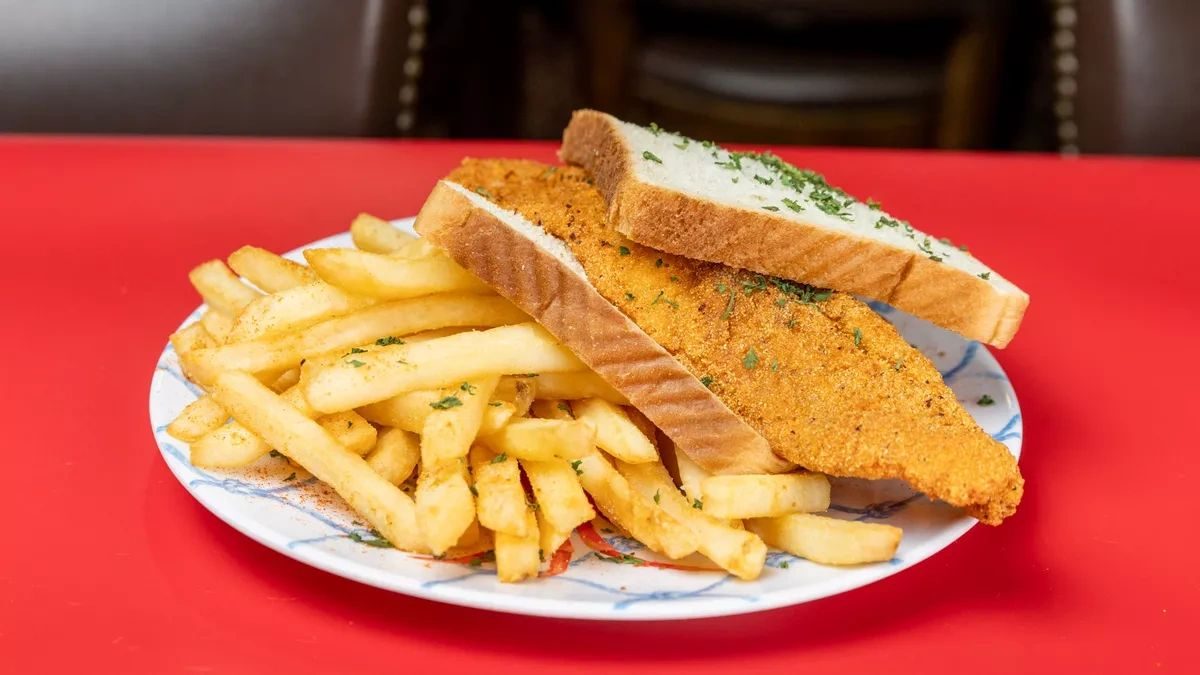 A fried fish sandwich with fries